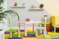 Stylish playroom with table, chairs and sofa Royalty Free Stock Photo