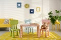Stylish playroom interior with table,  and sofa Royalty Free Stock Photo
