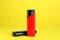 Stylish small pocket lighters on yellow background