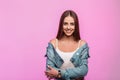 Stylish portrait joyful young woman in fashionable denim jacket in vintage white t-shirt smiling near modern pink wall in the Royalty Free Stock Photo