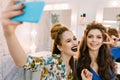 Stylish portrait two stylish attractive models with stylish makeups, luxury coiffures making selfie in hairdresser salon