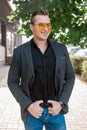 Stylish positive smiling young attractive guy of European appearance businessman portrait in jacket, shirt and jeans, in Royalty Free Stock Photo