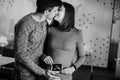 Stylish pregnant couple holding ultrasound scan of baby on baby bump and kissing. Young parents, happy mom and dad, holding in Royalty Free Stock Photo