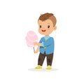 Stylish preschool kid standing with sweet cotton candy.