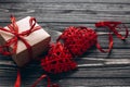 Stylish present and two red hearts with ribbon on rustic black w Royalty Free Stock Photo
