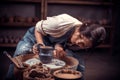 Stylish professional potter sculptor works with clay on a Potter`s wheel and at the table with the tools. Craft