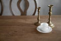 Stylish prop setting with antigue gold candle stick with white ceramic cup with plate setting on real natural wood table / copy Royalty Free Stock Photo