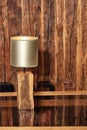 Stylish reading lamp and an old cracked wooden wall reflect on a polished wooden surface Royalty Free Stock Photo