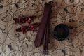 Stylish red bow-tie and tie with belt and cufflinks on bed. morn