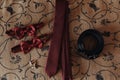 Stylish red bow-tie and tie with belt and cufflinks on bed. morn