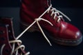 Stylish red shoes with laces tied together on black background, selective focus. High boots with shoelaces connected together, Royalty Free Stock Photo