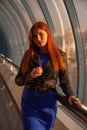 Stylish redhead woman walking in summer city at the sunset Royalty Free Stock Photo