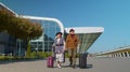 Stylish retired family couple granny grandfather walking with luggage suitcase bags to airport hall Royalty Free Stock Photo