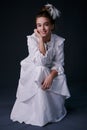 Stylish retro portrait of a teenage girl in a white dress. studio. dark background
