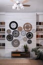 Stylish room interior with console table, beautiful houseplants and collection of different clocks on white wall Royalty Free Stock Photo