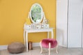 Stylish room interior with  dressing table near yellow wall Royalty Free Stock Photo