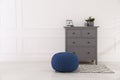 Stylish room interior with grey chest of drawers and blue pouf, space for text Royalty Free Stock Photo