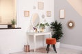 Stylish room interior with dressing table near light wall Royalty Free Stock Photo