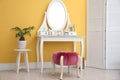 Stylish room interior with modern dressing table  yellow wall Royalty Free Stock Photo