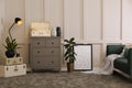 Stylish room interior with storage trunks, grey chest of drawers and sofa Royalty Free Stock Photo