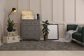 Stylish room interior with storage trunks, grey chest of drawers and comfortable sofa Royalty Free Stock Photo