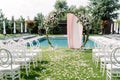 A stylish round green arch for a wedding ceremony on the lawn near the pool