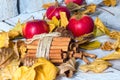 Stylish rustic or autumn wallpaper with cinnamon and apple and leaves on wooden background. space for text. cozy mood