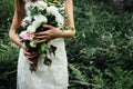 Stylish rustic bouquet in the hand of gorgeous boho bride on the Royalty Free Stock Photo