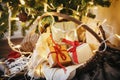 Stylish rustic christmas gift boxes in basket under christmas tr