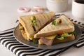 Stylish sandwich. Toasted double panini with ham, cheese fresh vegetables. Snack at work or lunch. Light background