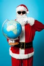 Stylish Santa in dark shades pointing at the globe Royalty Free Stock Photo
