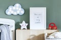 Stylish scandi childroom with wooden mock up photo frame, wooden toys, boxes, blocks and accessories Bright and sunny interior