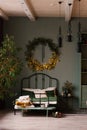 Stylish Scandinavian bedroom in green with a large double bed and a Christmas wreath on the wall Royalty Free Stock Photo