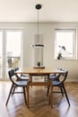 Stylish scandinavian dining room interior with design family table and chairs and accessories. Bright, spacious and sunny room. Royalty Free Stock Photo