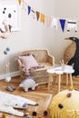 Stylish scandinavian interior of child room with natural toys, hanging decoration, design furniture, plush animals, teddy bears. Royalty Free Stock Photo