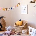 Stylish scandinavian interior of child room with natural toys, hanging decoration, design furniture, plush animals, teddy bears. Royalty Free Stock Photo