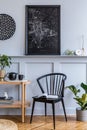 Stylish scandinavian living room interior with design black chair, wooden console, mock up poster map and decoration. Royalty Free Stock Photo