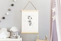 Stylish scandinavian nursery interior with hanging mock up poster, natural toys, teddy bears, children`s accessories and design