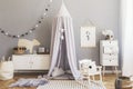 Stylish scandinavian nursery interior with hanging mock up poster, natural toys, teddy bears, children`s accessories and design Royalty Free Stock Photo