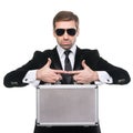 Stylish security guard holds metal suitcase. Royalty Free Stock Photo