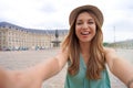 Stylish selfie girl in Bordeaux, France. Young tourist woman takes self portrait in Place de la Bourse square, Bordeaux, France Royalty Free Stock Photo