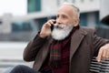 Stylish senior man talking on phone, sitting on bench Royalty Free Stock Photo