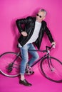 Stylish senior man wearing leather jacket, sunglesses and riding bicycle Royalty Free Stock Photo