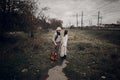 Stylish, sensual hipster couple in boho clothes, handsome musician man and gypsy girl holding hands in autumn field near railway Royalty Free Stock Photo