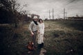 Stylish, sensual hipster couple in boho clothes, handsome musician man and gypsy girl holding hands in autumn field near railway Royalty Free Stock Photo