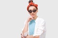Stylish serious brunette young woman wears black sunglasses, white shirt and trendy red headband, looks seriously directly into Royalty Free Stock Photo