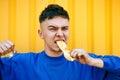 Stylish serious guy in a blue sweater, teeth chewing a lemon Royalty Free Stock Photo