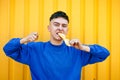 Stylish serious guy in a blue sweater, teeth chewing a lemon Royalty Free Stock Photo