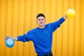 Stylish serious guy in a blue sweater, with yellow and blue inflatable balls