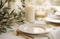 Stylish setting wedding table with place card with olive branch and eucalyptus leaves on white tablecloth Royalty Free Stock Photo